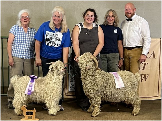 From the left, Lyn and Amy of The Pines Farm with their Champion White Buck, 143, and Jaycee and Rhonda hold Kahill of Rimini Stilly River Ranch, who was awarded Reserve Champion White Buck, and Judge Stewart. Photo: Sharon Chestnutt.